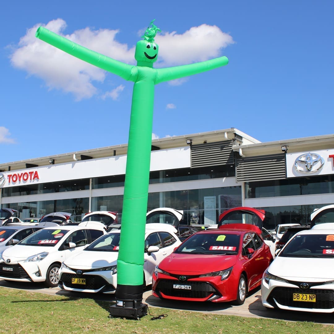 112G1 Green Air Dancer inflatable advertising man in front of Toyota car dealership.