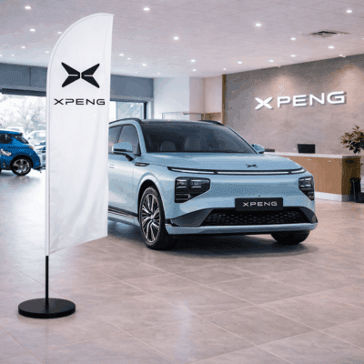 XPeng flag displayed in a showroom with an XPeng electric vehicle, highlighting automotive branding and dealership ambiance.